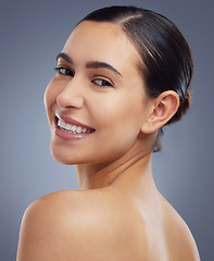 Image showing Im glowing, right. Studio shot of a beautiful young woman posing against a grey background.