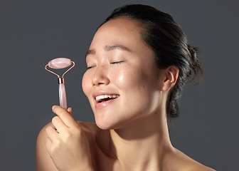Image showing People always ask about my skincare. Studio shot of a beautiful young woman holding a face roller.