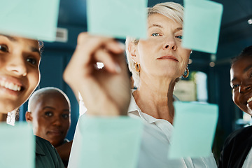 Image showing Time to brainstorm. an attractive and diverse group of businesswomen working with sticky notes on a glass wipe board in the boardroom.