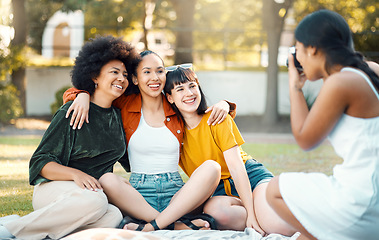 Image showing In the sweetness of friendship let there be laughter. a female taking photos of her friends in a park.