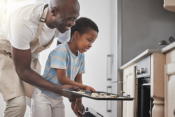 Image showing So we baked and sweated together. a father and son standing by the oven in the kitchen.