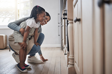 Image showing Theyre almost ready to come out. a little girl and her mother sitting in front of the oven.