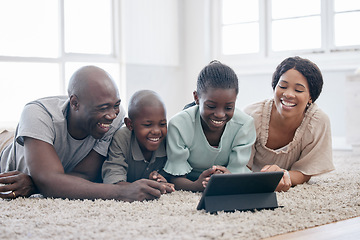 Image showing We start and end with the family. a family using s tablet while laying on the floor at home.