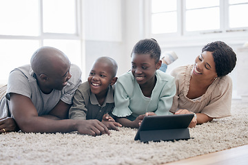 Image showing You dont choose your family. They are Gods gift. a family using s tablet while laying on the floor at home.