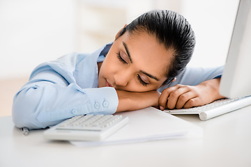 Image showing Just a little cat nap. a young businesswoman taking a nap at her desk.