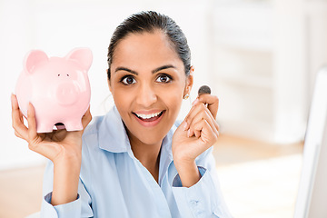 Image showing Its never too early to save. a young businesswoman saving money in her piggybank.