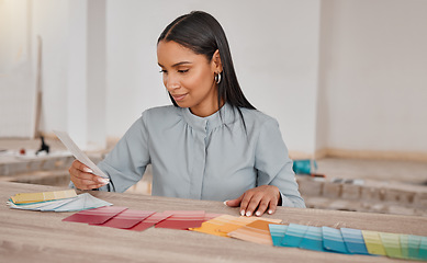 Image showing I like all of them. a young woman looking at different colour swatches while renovating her house.