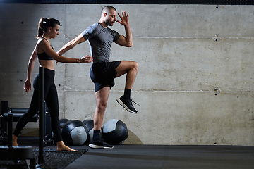 Image showing A fit couple in a modern gym, engaging in running exercises and showcasing their athletic prowess with a dynamic start.