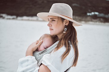 Image showing Youre safe in my arms. a young mother holding her baby while at the beach.