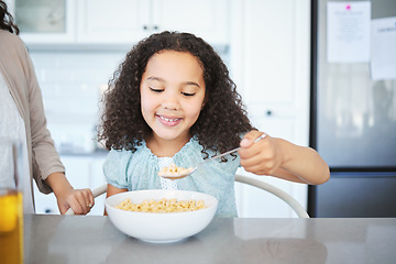 Image showing Woke up starving. an adorable little girl having breakfast at the kitchen table.