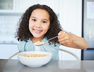 Image showing Would you like some. an adorable little girl having breakfast at the kitchen table.