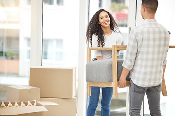 Image showing Shes the real muscle around here. a young couple moving a couch into their new home.