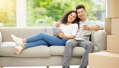 Image showing To be young and in-love...a young couple bonding on the sofa while using a digital tablet.