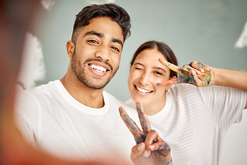 Image showing Cheers to the DIY challenge. a young couple taking a selfie while painting together at home.