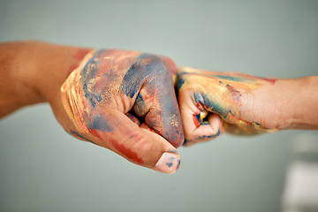 Image showing Lets spread our love all over this place. an unrecognizable couple sharing a fist bump while painting.