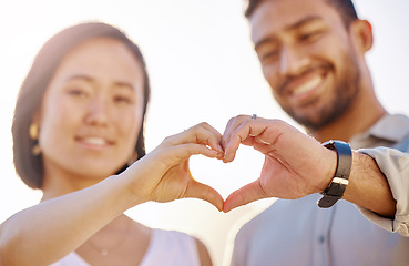 Image showing Love is in the air. an affectionate young couple making a heart shape with their hands on the beach.