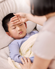 Image showing I think I should let him sleep in. a woman checking her sick childs temperature.