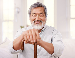 Image showing Nothing matters more than having a positive attitude. a senior man sitting at home with a wooden walking stick.