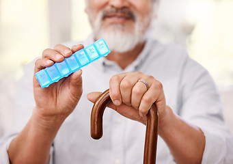 Image showing Im a little forgetful when it comes to medication so this helps. a senior man sitting with a walking stick and holding up a weekly pill box.