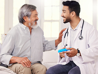 Image showing Im all about making life easier for my patients. a doctor holding a pill box while talking to a senior patient.