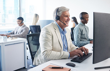 Image showing We have an amazing offer for you. a mature businessman using a headset and computer in a modern office.