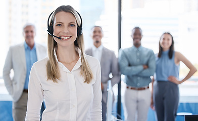 Image showing Lets make life a lot easier for you. Portrait of a mature businesswoman using a headset in a modern office with her team in the background.