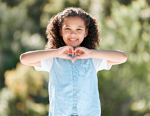 Image showing Show some love. a little girl forming a heart shape with her hands while standing outside.