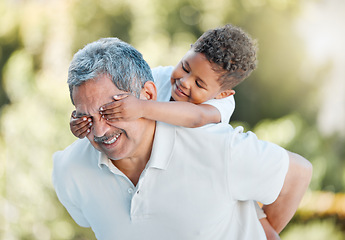 Image showing I always have so much fun with my grandson. a little boy covering his grandfathers eyes while playing outside.