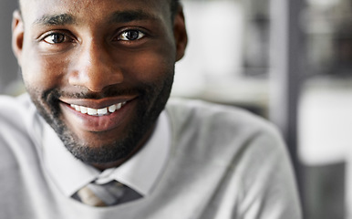 Image showing Short term goals lead to long term success. Portrait of a smiling young businessman sitting at a desk in an office.