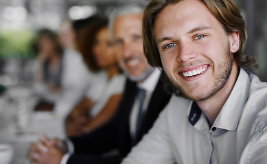 Image showing This meeting did me good. Portrait of a businessman sitting in a boardroom meeting with colleagues blurred in the background.