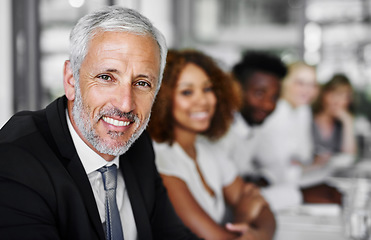 Image showing I love meetings, they are so informative. Portrait of a businessman sitting in a boardroom meeting with colleagues blurred in the background.