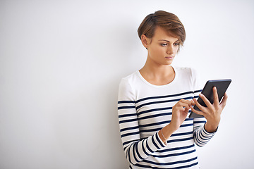 Image showing Staying connected. A cropped portrait of a beautiful young woman holding a tablet.