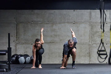 Image showing A fit couple in a modern gym, engaging in running exercises and showcasing their athletic prowess with a dynamic start.