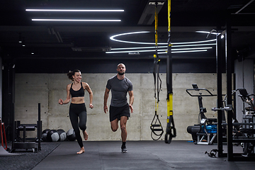 Image showing A fit couple in a modern gym, engaging in running exercises and showcasing their athletic prowess with a dynamic start.