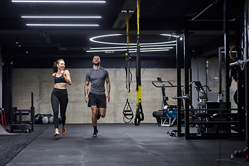 Image showing A fit couple in a modern gym, engaging in running exercises and showcasing their athletic prowess with a dynamic start.