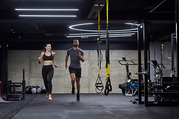 Image showing A fit couple in a modern gym, engaging in running exercises and showcasing their athletic prowess with a dynamic start.