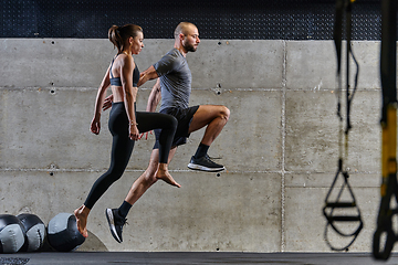 Image showing A fit couple exercising various types of jumps in a modern gym, demonstrating their physical fitness, strength, and athletic performance