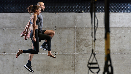 Image showing A fit couple exercising various types of jumps in a modern gym, demonstrating their physical fitness, strength, and athletic performance