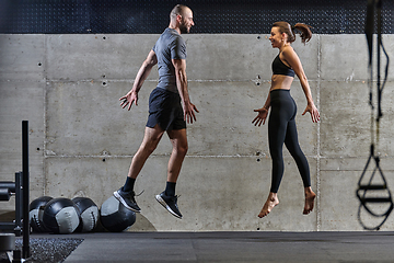 Image showing A fit couple exercising various types of jumps in a modern gym, demonstrating their physical fitness, strength, and athletic performance