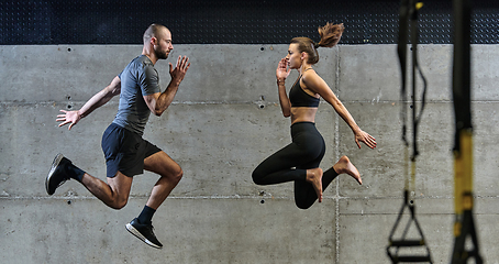 Image showing A fit couple exercising various types of jumps in a modern gym, demonstrating their physical fitness, strength, and athletic performance