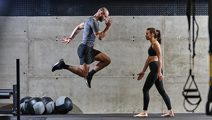 Image showing A fit couple exercising various types of jumps in a modern gym, demonstrating their physical fitness, strength, and athletic performance