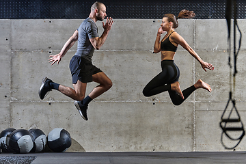 Image showing A fit couple exercising various types of jumps in a modern gym, demonstrating their physical fitness, strength, and athletic performance