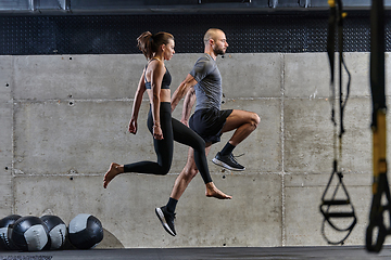 Image showing A fit couple exercising various types of jumps in a modern gym, demonstrating their physical fitness, strength, and athletic performance