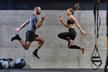 Image showing A fit couple exercising various types of jumps in a modern gym, demonstrating their physical fitness, strength, and athletic performance