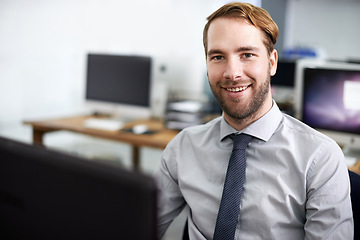 Image showing Happy to do business with you. A handsome businessman working at his desk.