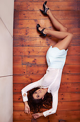 Image showing Shell spin your world upside down. Full length high angle shot of an attractive young woman lying on a hard wood floor.