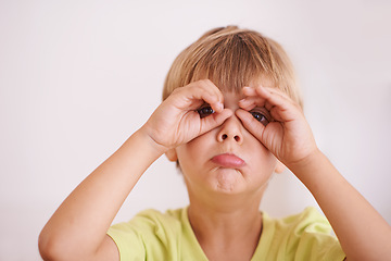 Image showing Silly faces. a cute little boy standing with his hands cupped around his eyes.