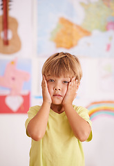 Image showing Oh no What will I tell Mom. A young boy holding his face in his hands with a worried expression.