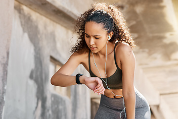 Image showing It didnt track anything. an attractive young woman looking contemplative while checking her watch during her outdoor workout.