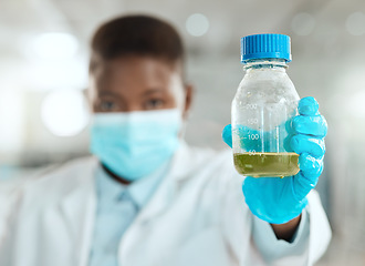 Image showing Im testing this today. an unrecognisable scientist holding a bottle of liquid for testing in her laboratory.